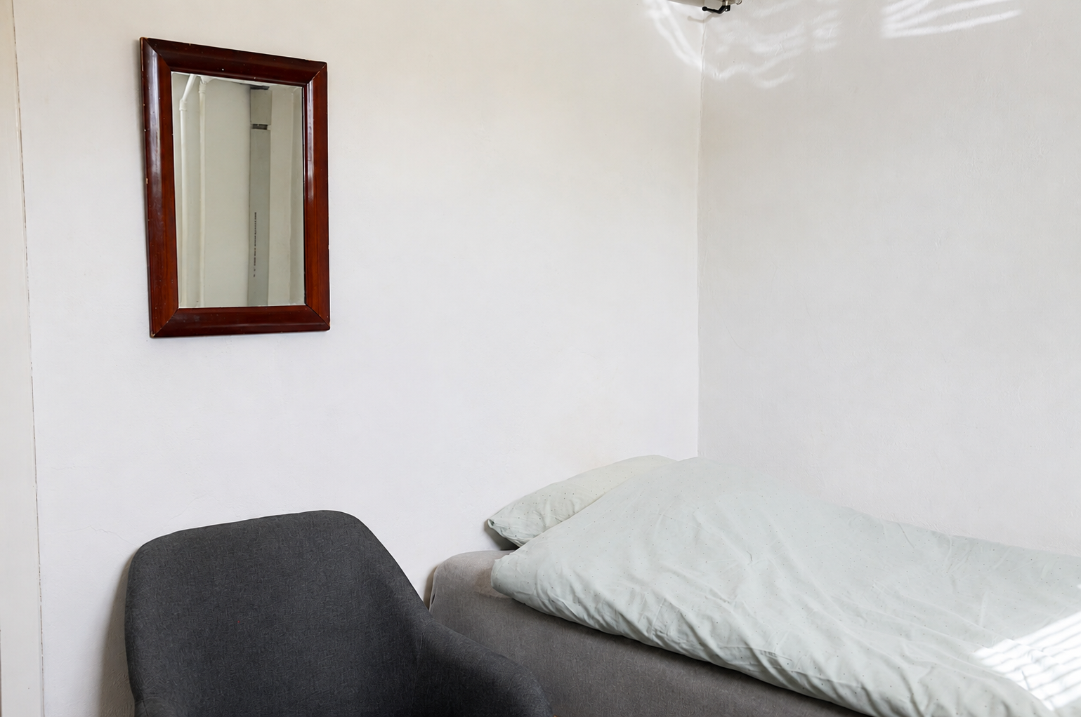 Værelse 1 med seng og spejl hos Roskilde Bed & Breakfast